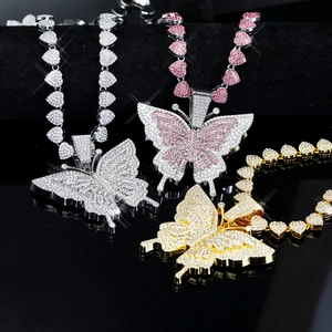 Gros plan de pendentifs papillon sertis de strass avec chaîne coeur en argent, or et rose