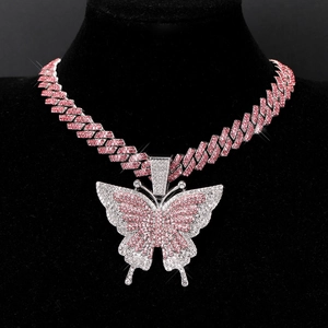 Macro shot of hip hop Cuban link chain with pink and white rhinestones and butterfly pendant