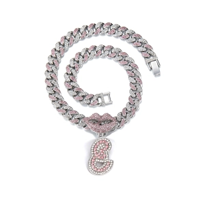 Close-up of hip hop Cuban link chain with pink rhinestone lips and letter S pendant