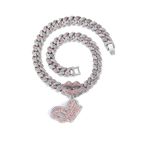 Detail of hip hop cuban chain with pink and white rhinestones and a red lip pendant