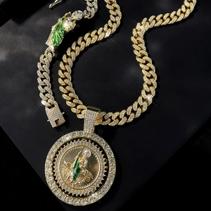 Macro detail of iced-out Cuban chain and Saint Jude pendant with green enamel and gold plating