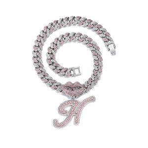 Close-up of hip-hop silver Cuban chain with pink lip pendant and letter A rhinestones