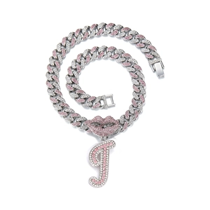 Detail of silver cuban chain with pink lips and rhinestone letter I pendant