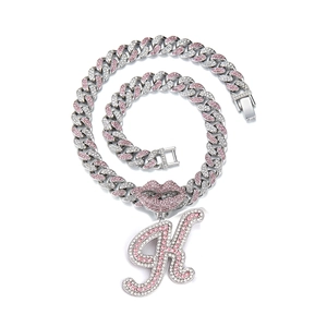 Macro shot of silver hip-hop necklace with pink rhinestone lip and letter K pendant