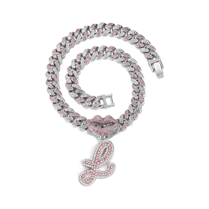 Close-up of hip-hop silver chain with pink crystal lips and letter L letter charm