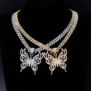 Détail de colliers papillon hip hop avec chaîne cubaine glacée en tons or et argent brillant