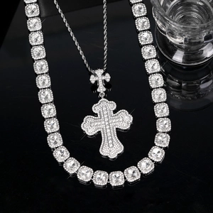 Macro shot of iced out cross pendant with sparkling rhinestones on tennis chain set