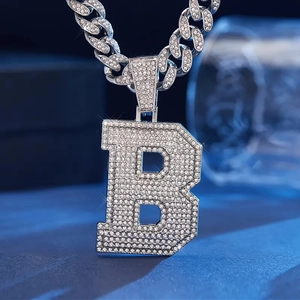 Macro shot of hip-hop letter B pendant with ice-out cubic zirconia and Cuban link chain