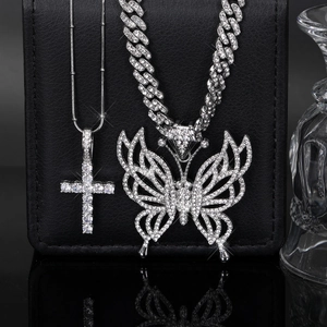 Détail de la chaîne cubaine argentée avec pendentif papillon et cristaux micro-pavés