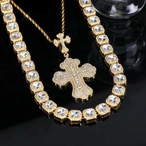 Macro shot of gold-plated iced out cross pendant with sparkling tennis chain set
