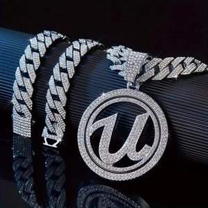 Macro shot of iced out Cuban link chain and sparkling letter U pendant necklace