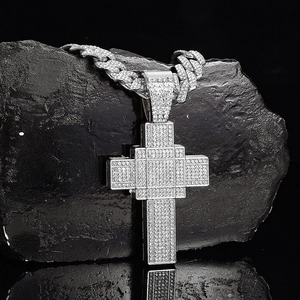 Macro shot of hip-hop cross pendant with iced-out crystals and heavy Cuban chain