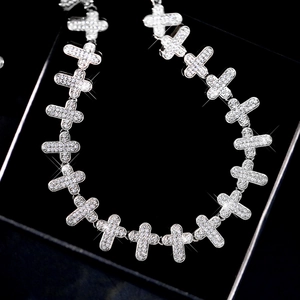 Nahaufnahme der Hip-Hop Kreuzkette mit funkelnden Diamanten auf schwarzem Samthintergrund