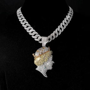 Macro detail of iced-out hip hop queen pendant with colorful cubic zirconia and cuban chain