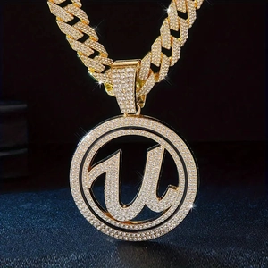 Macro shot of iced-out gold U-letter pendant with Cuban link chain for hip-hop style