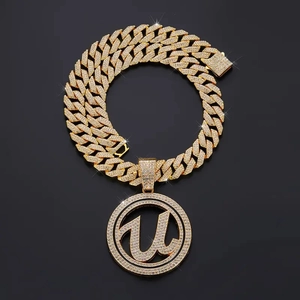 Iced out U-letter pendant on heavy Cuban link chain with gold plating and zircons