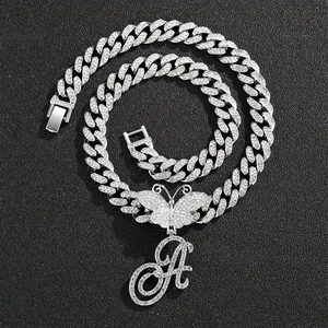 Vue macro du pendentif lettre A cursive avec papillon sur une chaîne cubaine glacée