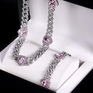 Dettaglio del set collana e bracciale a maglia cubana con cuori rosa e cristalli bianchi