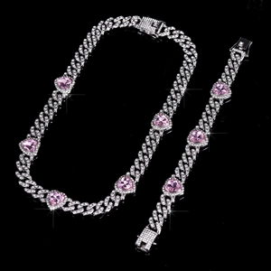 Dettaglio macro del set di gioielli a catena cubana con cristalli rosa a cuore