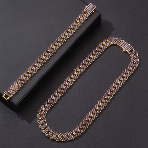 Détail du set de chaînes cubaines dorées avec strass bleus sertis sur présentoir noir
