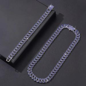 Détail de parure Cuban Link argentée avec strass bleus étincelants style hip hop
