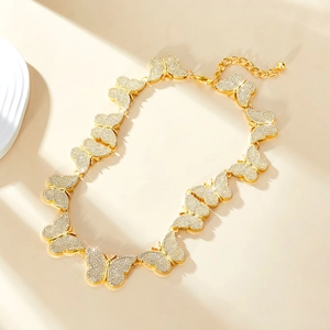 Détail d'un collier papillon doré avec des strass étincelants et une chaîne de réglage pratique