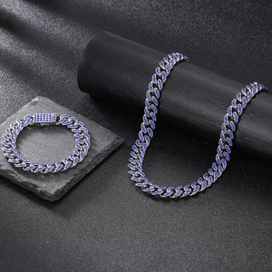 Détail d'un ensemble gourmette argentée avec strass bleu foncé sur un support noir