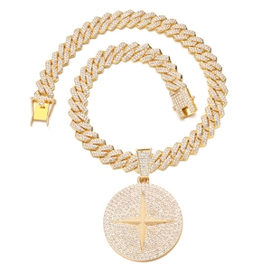 Detail van gouden Cuban-ketting en ronde hanger met sprankelend sterpatroon