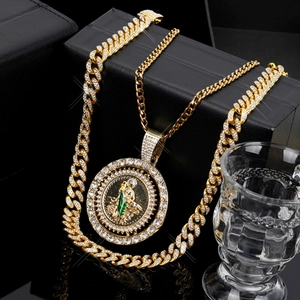 Detailed view of hip hop gold Cuban chain and St. Jude medal with green enamel and zircons