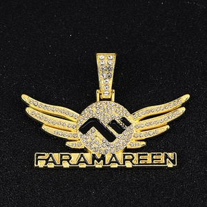 Makroansicht des vergoldeten Hip-Hop-Flügelanhängers mit Kristallen und Faramareen-Gravur