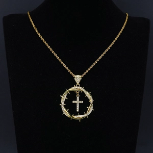 Detail of gold thorn ring pendant with crystal encrusted cross on a rope chain