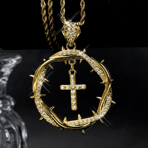 Macro shot of gold-plated twisted thorn cross pendant necklace with white zircons