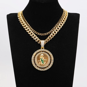 Close-up of double layer gold Cuban chain with iced out Saint Jude medallion on a bust