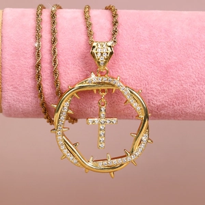 Close-up of gold hip hop pendant with thorn ring and cross on pink velvet stand