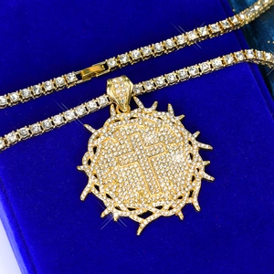 Gold hip hop tennis chain with iced out thorn cross pendant on blue velvet background