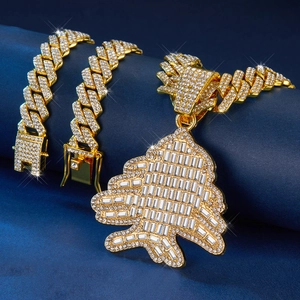 Vue macro d'une chaîne cubaine dorée et pendentif sapin de Noël serti de strass brillants