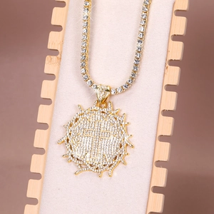 Close-up of a gold hip-hop cross pendant set with sparkling rhinestones on tennis chain