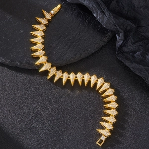 Hip hop gold spike bracelet set with iced out diamonds on black textured background