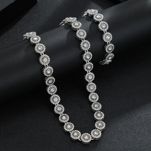 Dettaglio macro della collana floreale color argento con zirconi su espositore nero
