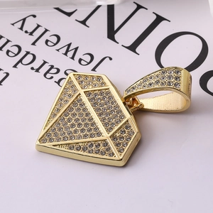 Dettaglio del ciondolo a forma di diamante dorato con cristalli incastonati stile hip hop