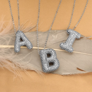 Silver iced-out bubble letter pendants A, B, and I with white cubic zirconia on chains
