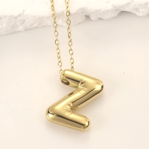 Detailed view of shiny gold balloon-style letter Z pendant with starburst engraving