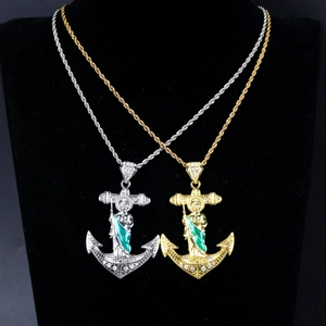 Detailed macro view of gold and silver hip hop anchor pendants with St. Jude icons
