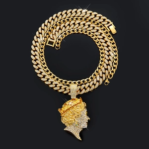 Makroaufnahme des Queen-Anhänger mit Diamanten und goldener Gliederkette im Hip-Hop-Stil