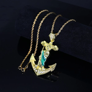 Macro detail of gold St. Jude anchor cross pendant with sparkling rhinestones on rope chain