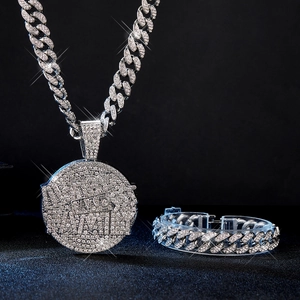 Detail of silver iced-out cuban chain set with sparkling rhinestones and a round pendant