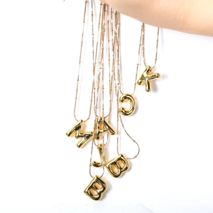 Goldene 3D-Ballon-Buchstabenanhänger-Halsketten mit Perlenkette auf weißem Hintergrund