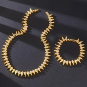 Macro shot of gold hip-hop jewelry set featuring spiked rhinestones on a textured background