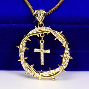 Close-up of hip hop pendant featuring thorns and iced out cross on velvet box