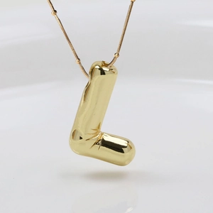 Detaillierte Nahaufnahme des goldenen L-Buchstabenanhängers an einer feinen Schlangenkette